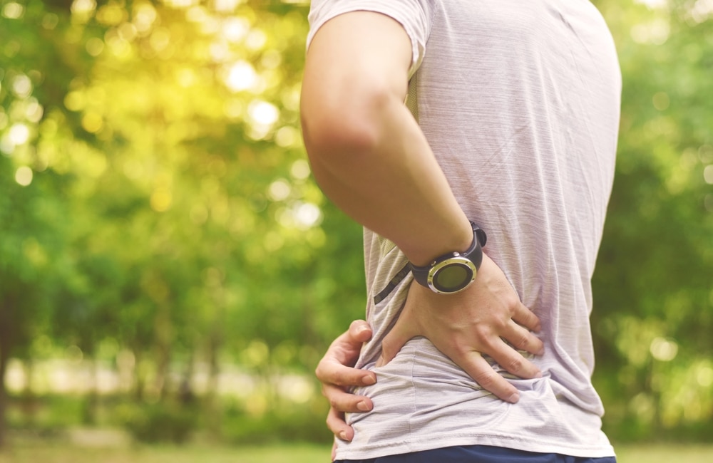 A cropped shot of a man with hip bursitis holding his hip and lower back