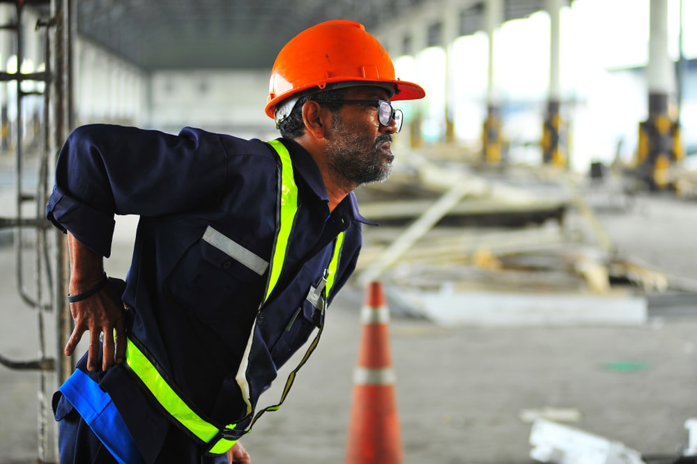 A construction worker holding his back after a back injury at work
