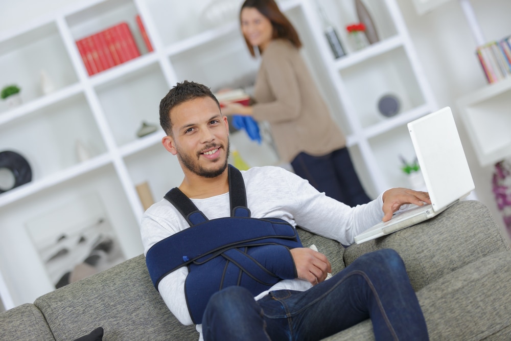Man with arm in a sling after orthopedic injury from a car accident