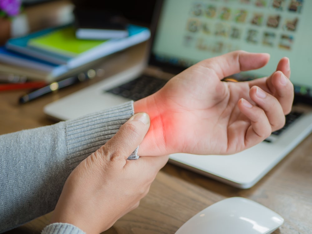 Close-up shot of a woman with carpal tunnel syndrome holding her wrist