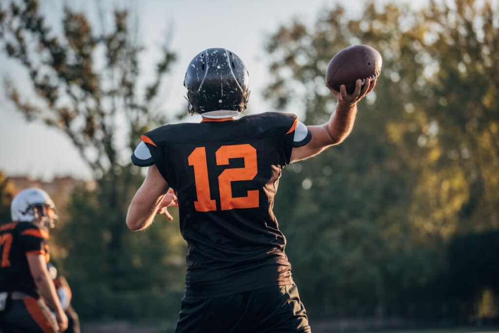 Man throwing a football after treatment for sports injuries at Union County Orthopaedic Group