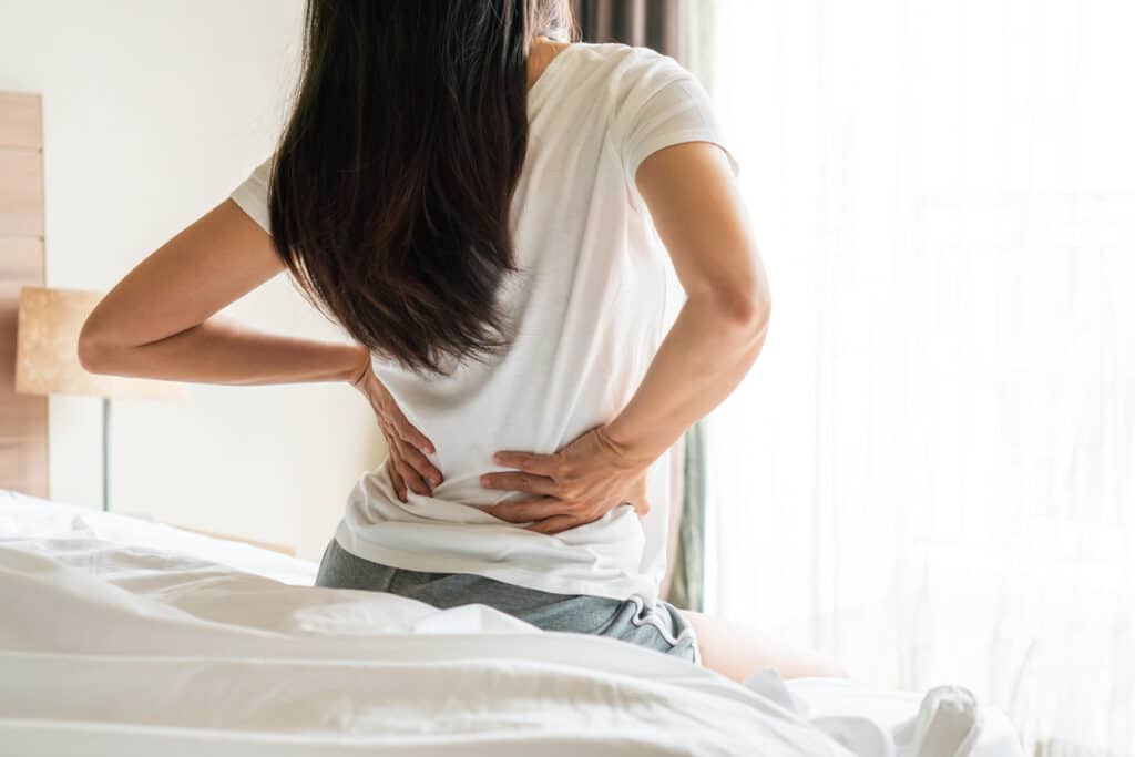 Woman with herniated disc holding her back