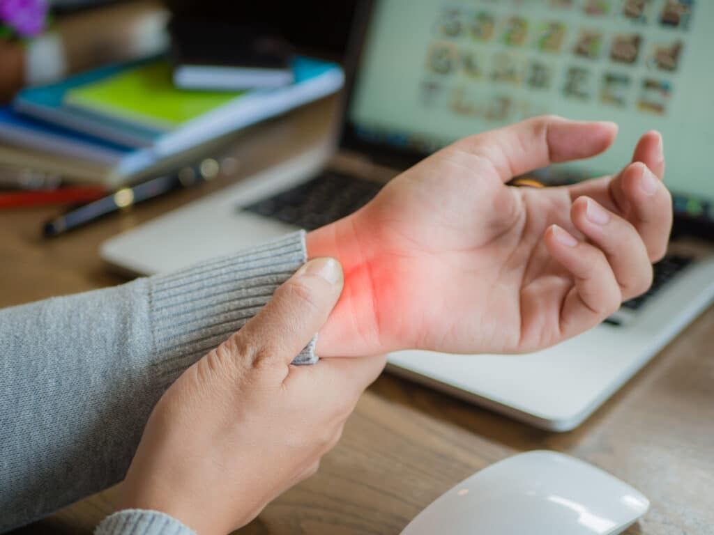 Woman with De Quervain's tenosynovitis holding her wrist