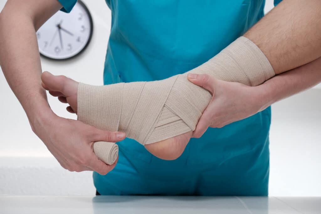 Doctor wrapping a patient's ankle at orthopedic urgent care in Linden, NJ